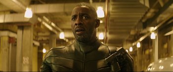 Movie still from “Fast & Furious Presents: Hobbs & Shaw” (2019), directed by David Leitch – A man in a leather jacket holding a gun; Close Up shot, Low angle