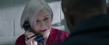 Movie still from “Fast & Furious Presents: Hobbs & Shaw” (2019), directed by David Leitch – An older woman talking on the phone with a younger man; Close Up shot, Over the shoulder angle