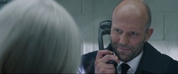 Movie still from “Fast & Furious Presents: Hobbs & Shaw” (2019), directed by David Leitch – A man talking on a phone in front of a mirror; Close Up shot, Over the shoulder angle