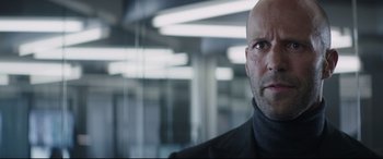 Movie still from “Fast & Furious Presents: Hobbs & Shaw” (2019), directed by David Leitch – A bald man in a black jacket looking at the camera; Close Up shot, Low angle