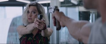 Movie still from “Fast & Furious Presents: Hobbs & Shaw” (2019), directed by David Leitch – A woman holding a gun in front of a mirror; Close Up shot, Over the shoulder angle