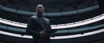 Movie still from “Fast & Furious Presents: Hobbs & Shaw” (2019), directed by David Leitch – A man holding a tablet in his hands; Medium shot, Low angle