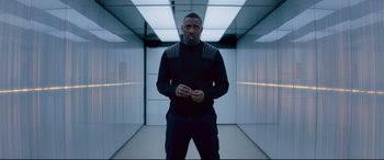 Movie still from “Fast & Furious Presents: Hobbs & Shaw” (2019), directed by David Leitch – A man standing in an elevator with his hands in his pockets; Medium shot, Low angle