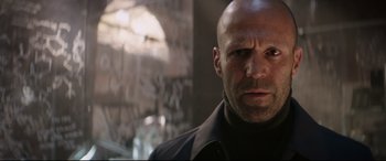 Movie still from “Fast & Furious Presents: Hobbs & Shaw” (2019), directed by David Leitch – A man with a bald head is looking at the camera; Close Up shot, Low angle