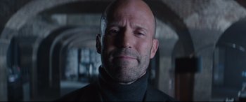 Movie still from “Fast & Furious Presents: Hobbs & Shaw” (2019), directed by David Leitch – A bald man with a beard is looking at the camera; Close Up shot, Low angle