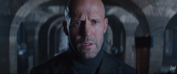 Movie still from “Fast & Furious Presents: Hobbs & Shaw” (2019), directed by David Leitch – A man with a bald head wearing a black jacket; Close Up shot, Low angle
