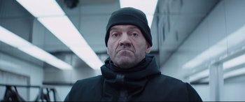 Movie still from “Fast & Furious Presents: Hobbs & Shaw” (2019), directed by David Leitch – A person wearing a jacket and a hat; Close Up shot, Low angle