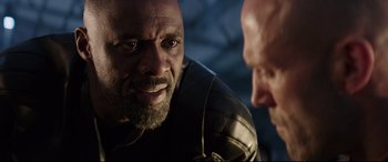 Movie still from “Fast & Furious Presents: Hobbs & Shaw” (2019), directed by David Leitch – A man with a goatee and a beard talking to another man with a goatee; Close Up shot, Over the shoulder angle