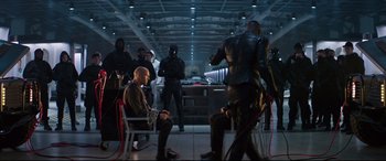 Movie still from “Fast & Furious Presents: Hobbs & Shaw” (2019), directed by David Leitch – A group of people in a room next to each other; Wide shot, Over the shoulder angle