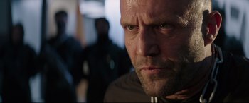 Movie still from “Fast & Furious Presents: Hobbs & Shaw” (2019), directed by David Leitch – A man's face in a dark room; Close Up shot, Low angle