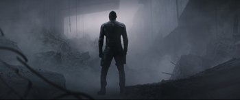 Movie still from “Fast & Furious Presents: Hobbs & Shaw” (2019), directed by David Leitch – A man standing in the middle of a foggy area; Wide shot, Low angle