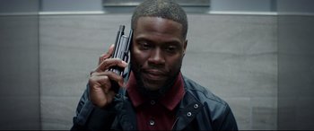 Movie still from “Fast & Furious Presents: Hobbs & Shaw” (2019), directed by David Leitch – A man holding a cell phone up to his ear; Close Up shot, Over the shoulder angle