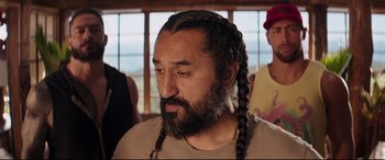 Movie still from “Fast & Furious Presents: Hobbs & Shaw” (2019), directed by David Leitch – A man with long black hair and a beard; Close Up shot, Over the shoulder angle