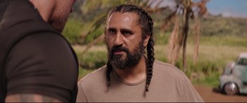 Movie still from “Fast & Furious Presents: Hobbs & Shaw” (2019), directed by David Leitch – A man with long hair and a beard; Close Up shot, Over the shoulder angle