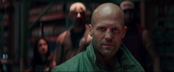 Movie still from “Fast & Furious Presents: Hobbs & Shaw” (2019), directed by David Leitch – A man with a bald head is looking at the camera; Close Up shot, Low angle