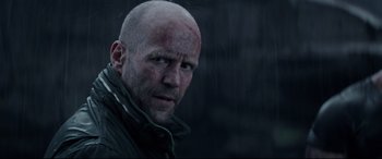 Movie still from “Fast & Furious Presents: Hobbs & Shaw” (2019), directed by David Leitch – A man with a bald head in the rain; Close Up shot, Low angle