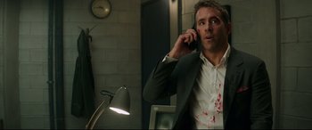 Movie still from “Fast & Furious Presents: Hobbs & Shaw” (2019), directed by David Leitch – A man in a white shirt is talking on a phone; Medium shot, Over the shoulder angle