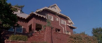 Movie still from “Cellular” (2004), directed by David R. Ellis – A brick building with a brick wall on top of it; Extreme Wide shot, Low angle