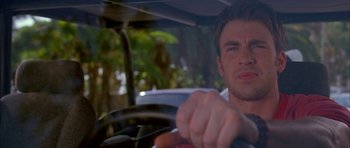 Movie still from “Cellular” (2004), directed by David R. Ellis – A young man driving a car in a tropical setting; Close Up shot, Low angle