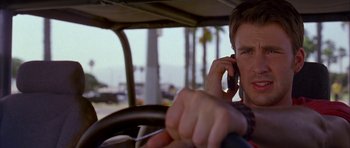 Movie still from “Cellular” (2004), directed by David R. Ellis – A man on a cell phone while driving a car; Close Up shot, Low angle