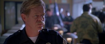 Movie still from “Cellular” (2004), directed by David R. Ellis – A man with a mustache and a police uniform; Close Up shot, Low angle