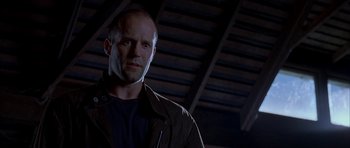 Movie still from “Cellular” (2004), directed by David R. Ellis – A man with a bald head wearing a black shirt; Close Up shot, Low angle