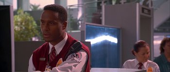 Movie still from “Cellular” (2004), directed by David R. Ellis – A man in a red and white jacket is looking at a monitor; Close Up shot, Low angle