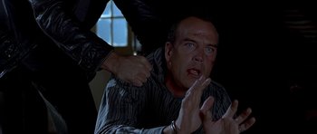 Movie still from “Cellular” (2004), directed by David R. Ellis – A man with blood all over his face is being held down by another man; Close Up shot, Over the shoulder angle