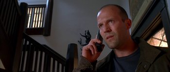 Movie still from “Cellular” (2004), directed by David R. Ellis – A man talking on a cell phone while standing in front of a staircase; Close Up shot, Low angle