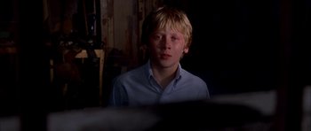 Movie still from “Cellular” (2004), directed by David R. Ellis – A young boy in a blue shirt is looking at the camera; Close Up shot, Over the shoulder angle