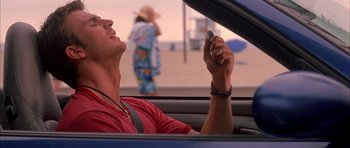 Movie still from “Cellular” (2004), directed by David R. Ellis – A man sitting in the back of a car looking at his cell phone; Close Up shot, Low angle