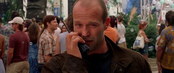 Movie still from “Cellular” (2004), directed by David R. Ellis – A man talking on a cell phone in front of a group of onlookers; Close Up shot, Low angle