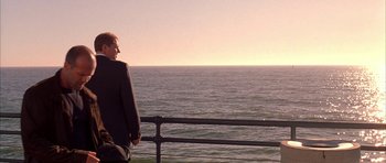 Movie still from “Cellular” (2004), directed by David R. Ellis – A man standing on a pier looking out at the ocean; Wide shot, Over the shoulder angle