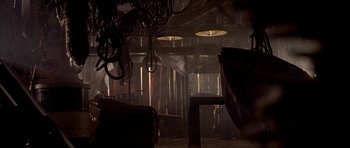 Movie still from “Cellular” (2004), directed by David R. Ellis – A dark room with lights hanging from the ceiling; Wide shot, High angle