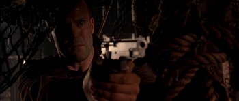 Movie still from “Cellular” (2004), directed by David R. Ellis – A person holding a gun in a dark room; Close Up shot, Low angle