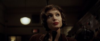 Movie still from “Changeling” (2008), directed by Clint Eastwood – A woman wearing headphones and looking to her left; Close Up shot, Over the shoulder angle
