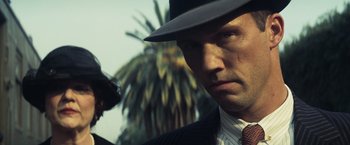 Movie still from “Changeling” (2008), directed by Clint Eastwood – A person wearing a suit and a hat; Close Up shot, Low angle