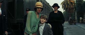 Movie still from “Changeling” (2008), directed by Clint Eastwood – A woman standing next to a young boy in front of a train; Medium shot, Low angle