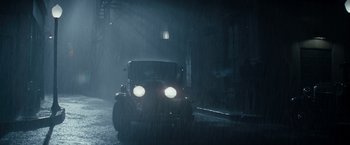 Movie still from “Changeling” (2008), directed by Clint Eastwood – An old car driving down a street in the rain; Extreme Wide shot, High angle
