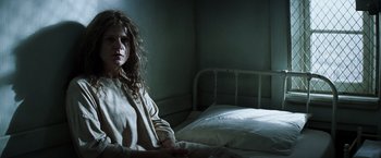 Movie still from “Changeling” (2008), directed by Clint Eastwood – A woman sitting on a bed in a dark room; Medium shot, High angle