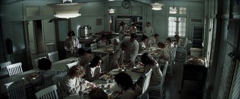 Movie still from “Changeling” (2008), directed by Clint Eastwood – A group of people sitting at a table eating food; Wide shot, High angle