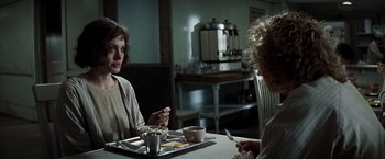 Movie still from “Changeling” (2008), directed by Clint Eastwood – Two women sitting at a table with a tray of food; Medium shot, Over the shoulder angle