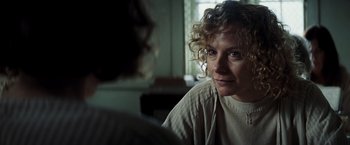 Movie still from “Changeling” (2008), directed by Clint Eastwood – A woman sitting in a room looking at the camera; Close Up shot, Over the shoulder angle