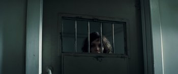Movie still from “Changeling” (2008), directed by Clint Eastwood – A woman looking through bars of an old window; Close Up shot, High angle