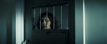 Movie still from “Changeling” (2008), directed by Clint Eastwood – A woman looking through a jail cell window; Close Up shot, Low angle