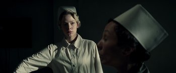 Movie still from “Changeling” (2008), directed by Clint Eastwood – A woman wearing a nurse's hat looking at herself in the mirror; Medium shot, Low angle
