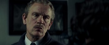 Movie still from “Changeling” (2008), directed by Clint Eastwood – An older man wearing a sweater and a tie; Close Up shot, Low angle