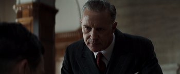 Movie still from “Changeling” (2008), directed by Clint Eastwood – An older man wearing a suit and tie; Close Up shot, Low angle