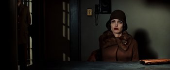 Movie still from “Changeling” (2008), directed by Clint Eastwood – A woman wearing a brown coat and a hat; Medium shot, Low angle