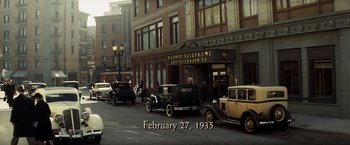 Movie still from “Changeling” (2008), directed by Clint Eastwood – An antique car parked in front of an antique store; Extreme Wide shot, High angle
